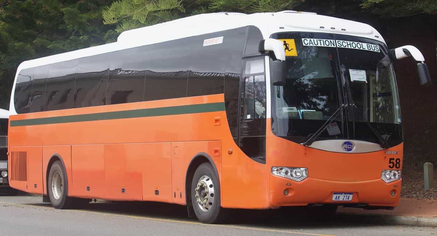 An orange school bus parked at the kerb